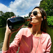 Beautiful woman drinking champagne from the bottle on a boat Beautiful woman drinking champagne from the bottle on a boat