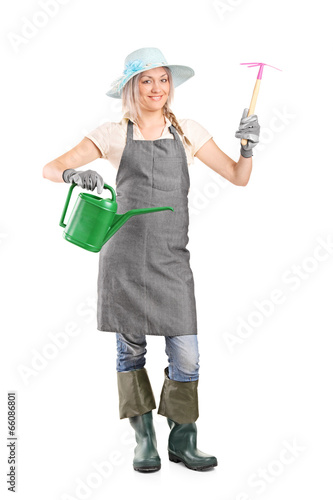 Photo: Female gardener holding mattock and watering can Female gardener holding mattock and watering can