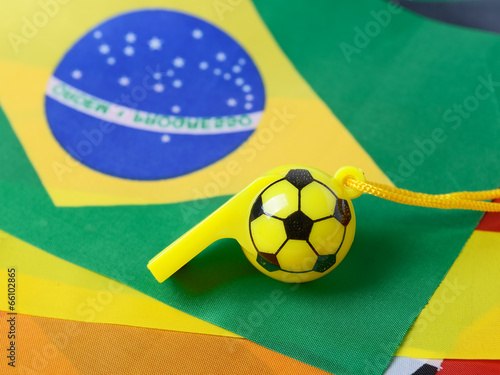 Photo: football shape whistle on brazil flag background. football shape whistle on brazil flag background.