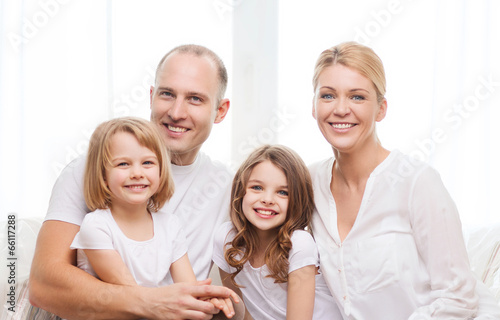 Photo: smiling parents and two little girls at home smiling parents and two little girls at home