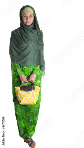 Photo: Muslim woman in green dress, hijab with yellow handbag Muslim woman in green dress, hijab with yellow handbag