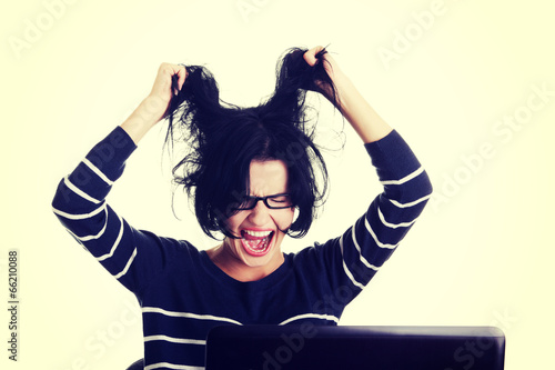 Photo: Frustrated woman working on laptop Frustrated woman working on laptop