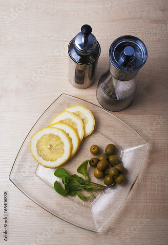 Photo: arugula, lemon and olives with spices on the table arugula, lemon and olives with spices on the table