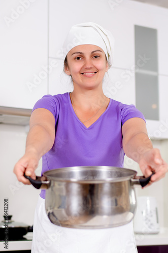 Photo: Laughing attractive cook with a big pot Laughing attractive cook with a big pot
