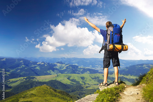 Photo: Tourist on peak. Sport and active life concept Tourist on peak. Sport and active life concept