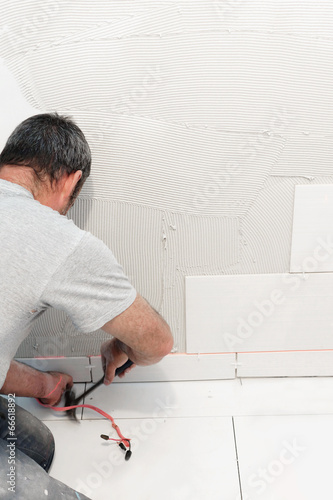 Photo: Worker installing ceramic tiles Worker installing ceramic tiles