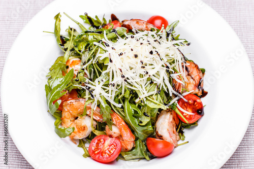 Photo: Salad with arugula and shrimps in a white plate Salad with arugula and shrimps in a white plate
