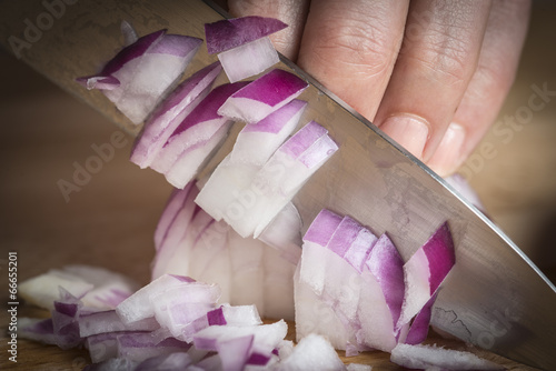 Photo: Cortando cebolla con un cuchillo en la cocina sobre la tabla Cortando cebolla con un cuchillo en la cocina sobre la tabla