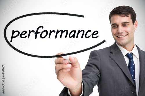 Photo: Businessman writing the word performance Businessman writing the word performance