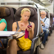 Lady traveling by train using smartphone. Lady traveling by train using smartphone.