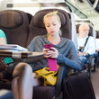 Lady traveling by train using smartphone. Lady traveling by train using smartphone.