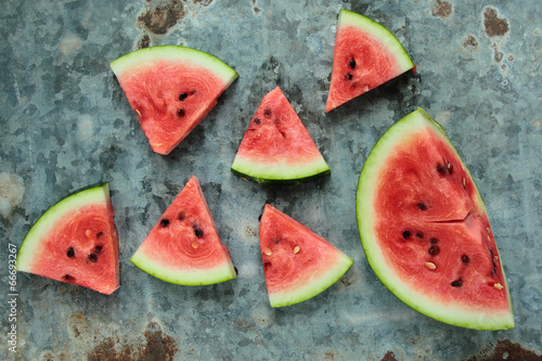 Photo: Fresh watermelon sliced in triangles on old metal board Fresh watermelon sliced in triangles on old metal board