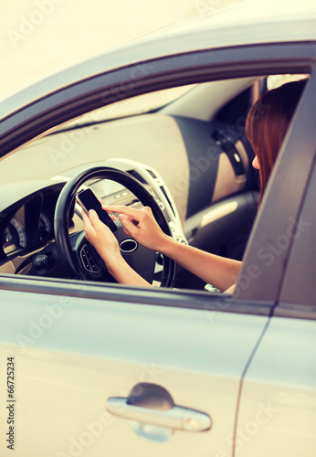 Photo: woman using phone while driving the car woman using phone while driving the car