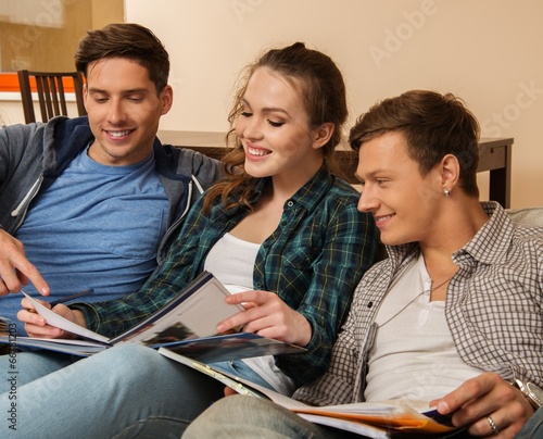 Photo: Three young students preparing for exams in apartment interior Three young students preparing for exams in apartment interior
