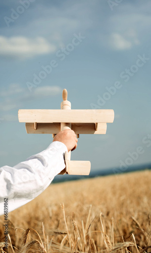 Photo: Little boy playing in farmland with a toy airplane Little boy playing in farmland with a toy airplane