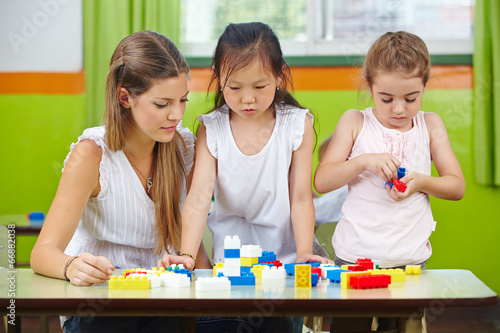 Photo: Children playing with building blocks in kindergarten Children playing with building blocks in kindergarten