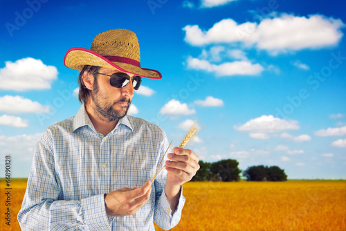Photo: Farmer with cowboy straw hat in wheat field Farmer with cowboy straw hat in wheat field