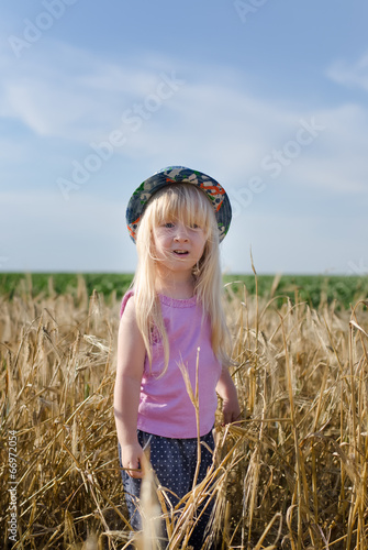 Photo: Little girl walking in a wheat field Little girl walking in a wheat field