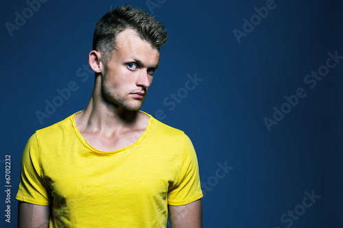 Photo: Emotive portrait of muscular young handsome man in bright yellow Emotive portrait of muscular young handsome man in bright yellow