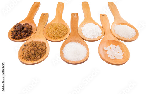 Photo: Various type of sugar on wooden spoon over white background Various type of sugar on wooden spoon over white background