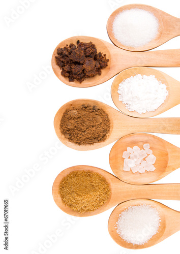 Photo: Various type of sugar on wooden spoon over white background Various type of sugar on wooden spoon over white background