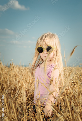 Photo: Pretty little girl in trendy yellow sunglasses Pretty little girl in trendy yellow sunglasses