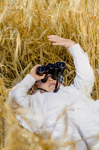 Photo: Cute boy lying down in a field of ripe wheat Cute boy lying down in a field of ripe wheat