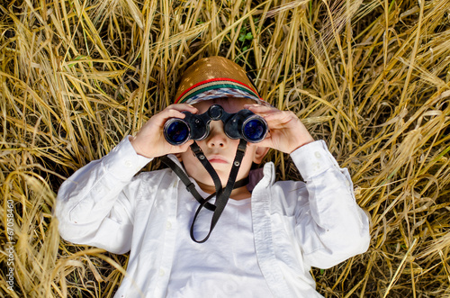 Photo: Cute boy lying down in a field of ripe wheat Cute boy lying down in a field of ripe wheat