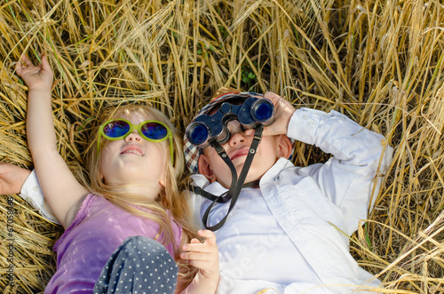 Photo: Boy and girl playing in grass with binoculars Boy and girl playing in grass with binoculars