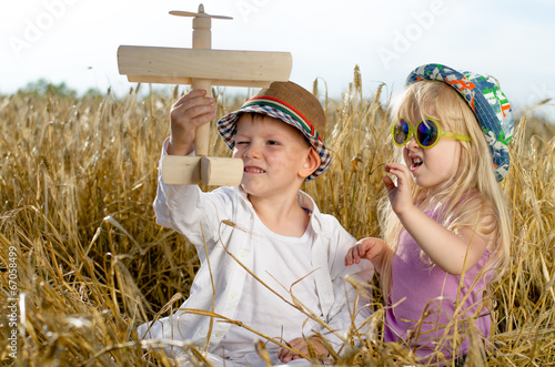 Photo: Two young children playing with a model plane Two young children playing with a model plane