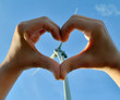 Heart from hands with a wind turbine in the background Heart from hands with a wind turbine in the background