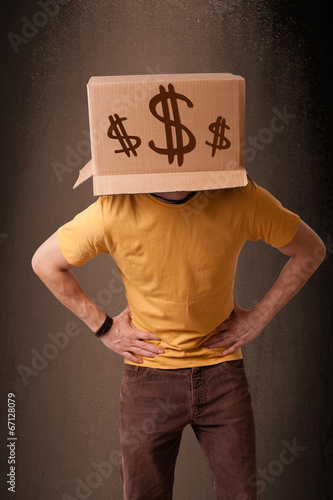 Photo: Young man gesturing with a cardboard box on his head with dollar Young man gesturing with a cardboard box on his head with dollar