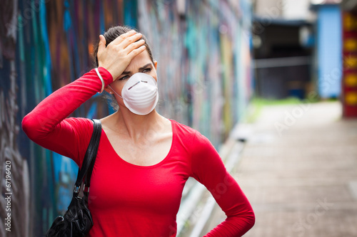 Photo: Woman with headache wearing a face mask Woman with headache wearing a face mask
