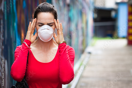 Photo: Woman with headache wearing face mask Woman with headache wearing face mask