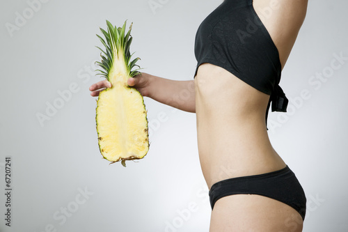 Photo: Young woman's body with pineapple Young woman's body with pineapple