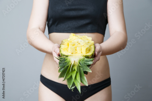 Photo: Young woman's body with pineapple Young woman's body with pineapple