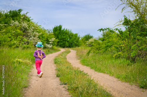Photo: Small girl in a colorful outfit on a country track Small girl in a colorful outfit on a country track