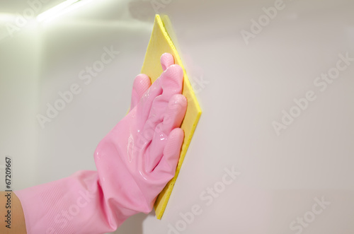 Photo: Gloved hand wiping a white surface with a cloth Gloved hand wiping a white surface with a cloth