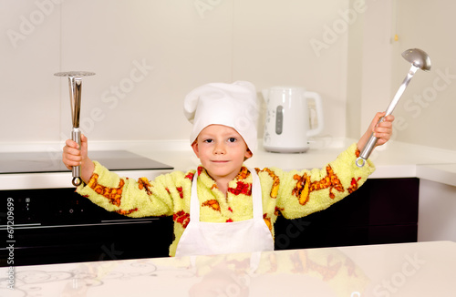 Photo: Cute boy chef displaying his utensils Cute boy chef displaying his utensils