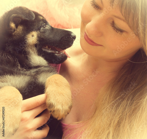 Photo: young woman holding a German Shepherd puppy young woman holding a German Shepherd puppy