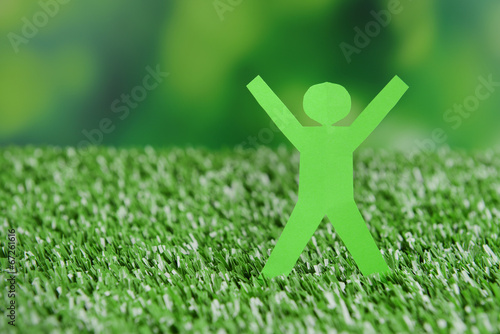 Photo: Paper people on green grass, close up Paper people on green grass, close up