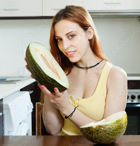 Photo: woman holding melon at kitchen woman holding melon at kitchen