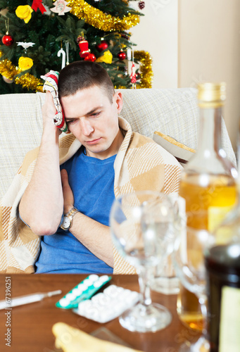 Photo: Suffering man with hangover with towel in hand Suffering man with hangover with towel in hand