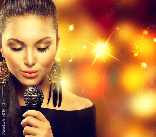 Photo: Singing Woman with Microphone over Blinking Background Singing Woman with Microphone over Blinking Background
