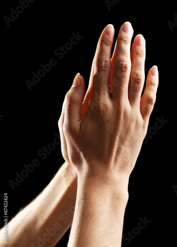 Photo: Human hands on black background Human hands on black background