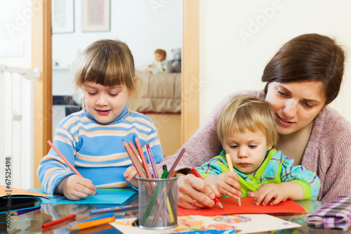 Photo: Woman and two children with pencils in home Woman and two children with pencils in home
