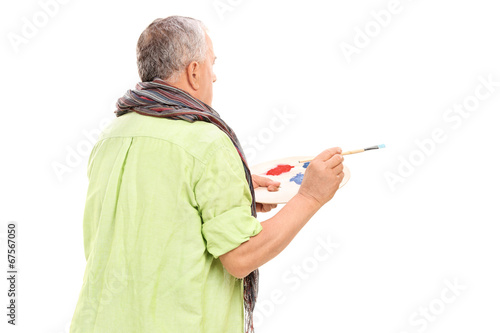 Photo: Mature painter holding a paintbrush Mature painter holding a paintbrush