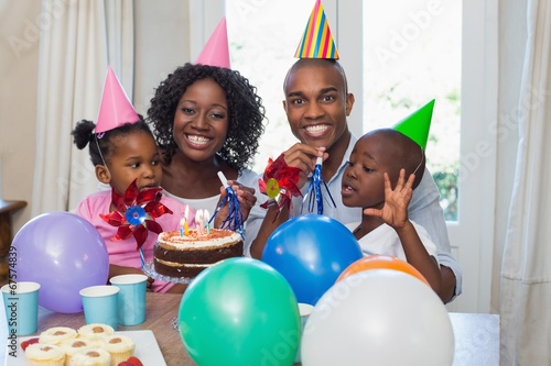 Photo: Happy family celebrating a birthday together at table Happy family celebrating a birthday together at table