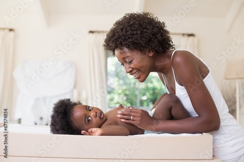 Photo: Happy mother with baby girl on changing table Happy mother with baby girl on changing table