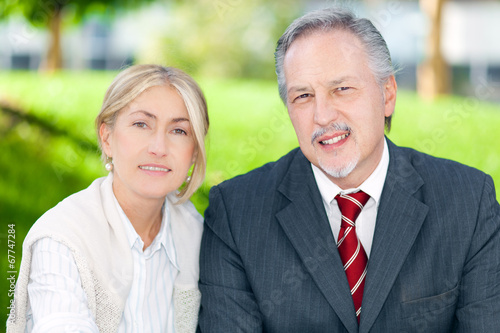 Photo: Two business people smiling in an urban setting Two business people smiling in an urban setting